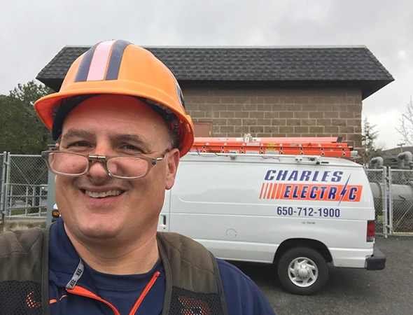 A happy technician in a hard hat finishing an oil change as part of our generator maintenance services.
