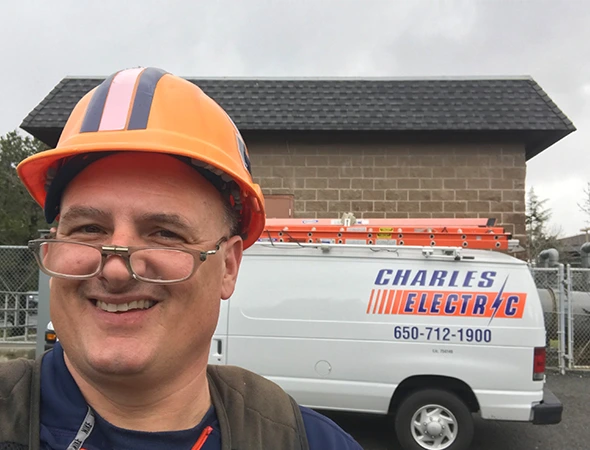 A friendly repairman smiling while helping a family with expert generator maintenance services.