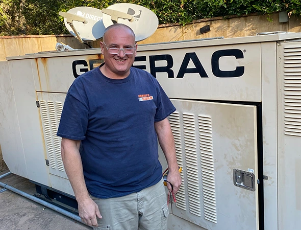 Our specialist standing next to a large Generac unit after completing a hybrid backup power setup.