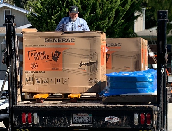 A technician standing in the back of a truck with a new unit for an expert standby generator installation.