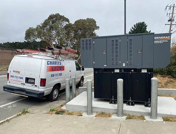 Our Charles Electric service van parked next to a robust hybrid power system during an Emerald Hills visit.