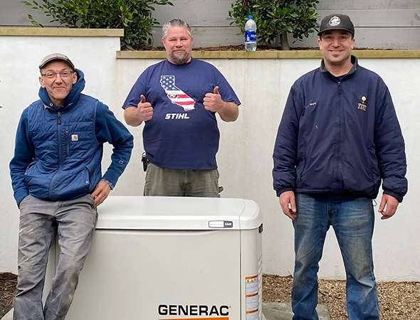 Three team members in Los Altos standing behind a white generator after finishing a hybrid system repair.