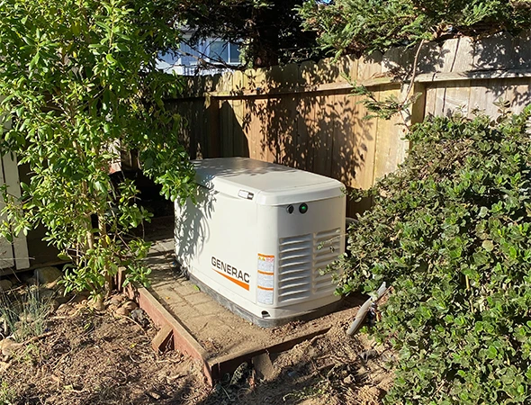 Tucked away in a Menlo Park garden, this white standby generator is fully set up and ready for use.