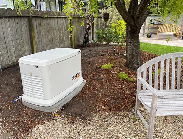 A clean, professional setup of a residential generator placed on a gravel pad in Menlo Park.