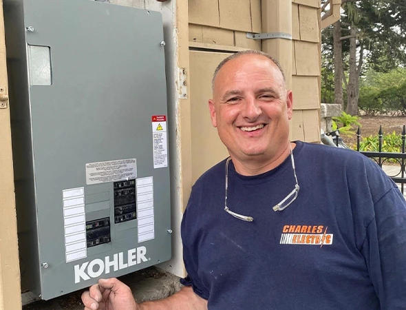 A close-up of our specialist standing with a high-quality Kohler power box in Woodside.