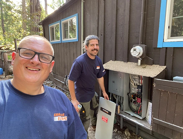 Two of our team members working together on an outdoor electrical panel integration in Woodside.